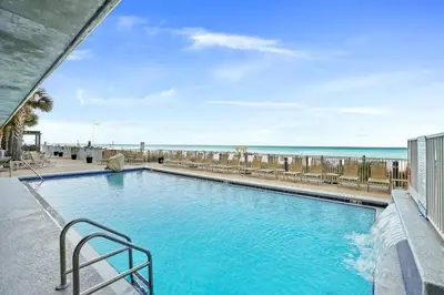 a swimming pool with the beach in the background at Emerald Isle by Panhandle Getaways in Panama City Beach