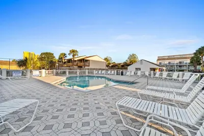 a swimming pool with lounge chairs and a swimming poolvisorvisor at Endless Summer by Panhandle Getaways in Panama City Beach