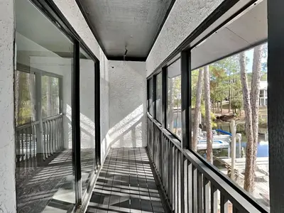 a balcony of a house with glass windows at Easy on Eastern Lake in Santa Rosa Beach
