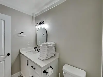 a bathroom with a sink and a toilet and a mirror at Easy on Eastern Lake in Santa Rosa Beach