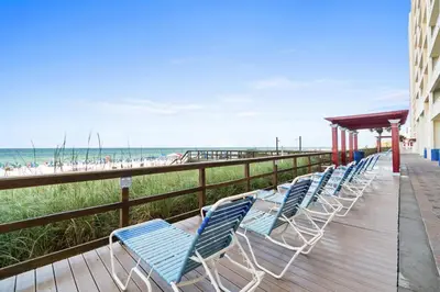 a row of blue chairs on a boardwalk next to the beach at Majestic Beach Resort Tower I by Panhandle Getaways in Panama City Beach