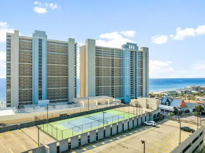 a large building with a tennis court in front of it at Majestic Beach Resort Tower I by Panhandle Getaways in Panama City Beach