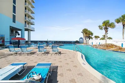 a pool at a resort with chairs and a swimming pool at Majestic Beach Towers Resort by Panhandle Getaways in Panama City Beach