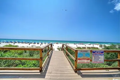 a wooden boardwalk leading to the beach with a sign at Majestic Beach Towers Resort by Panhandle Getaways in Panama City Beach
