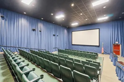 a lecture room with green chairs and a screen at Majestic Beach Towers Resort by Panhandle Getaways in Panama City Beach
