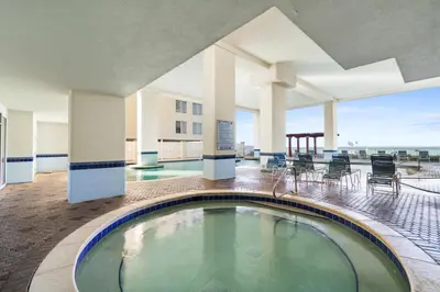 a pool in a building with chairs and tables at Majestic Beach Towers Resort by Panhandle Getaways in Panama City Beach