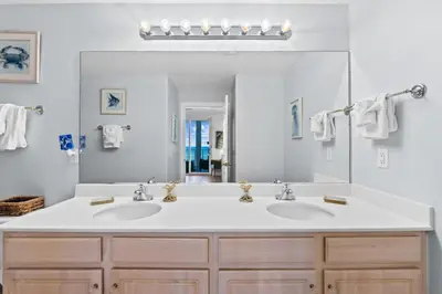 a bathroom with two sinks and a large mirror at Ocean Ritz by Panhandle Getaways in Panama City Beach