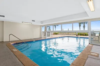 a large swimming pool with blue water in a building at Ocean Villa by Panhandle Getaways in Panama City Beach