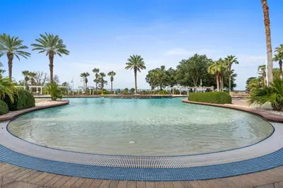 a swimming pool with palm trees in a resort at Reflections by Panhandle Getaways in Panama City Beach