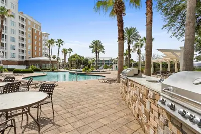 a patio with a table and chairs and a pool at Reflections by Panhandle Getaways in Panama City Beach
