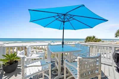 a blue table and chairs on a balcony with the beach at Sailfish by Panhandle Getaways in Panama City Beach