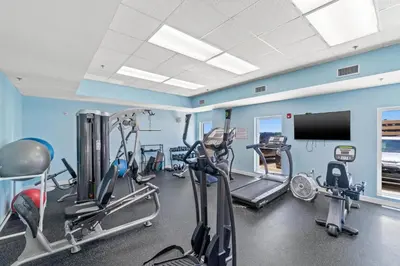 a gym with several tread machines and a flat screen tv at Seychelles Resort by Panhandle Getaways in Panama City Beach