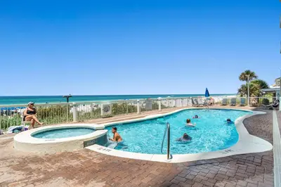 a swimming pool with people in it next to the beach at Seychelles Resort by Panhandle Getaways in Panama City Beach