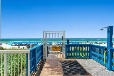 a blue gate with the beach in the background at Seychelles Resort by Panhandle Getaways in Panama City Beach