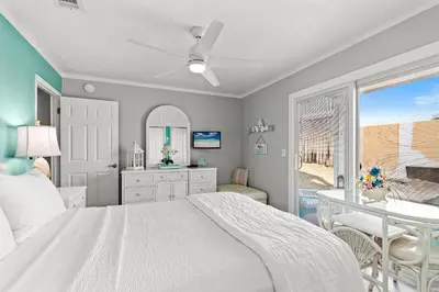 a bedroom with a bed and a table and a window at Southwind by Panhandle Getaways in Panama City Beach