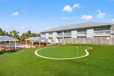 a building with a green yard with a golf course at Southwind by Panhandle Getaways in Panama City Beach