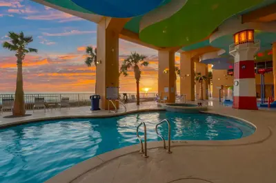 a large swimming pool in a building with palm trees at Splash Beach Resort by Panhandle Getaways in Panama City Beach