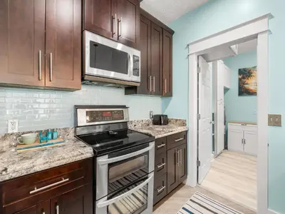 a kitchen with a stove and a microwave at Orange Crush in Panama City Beach