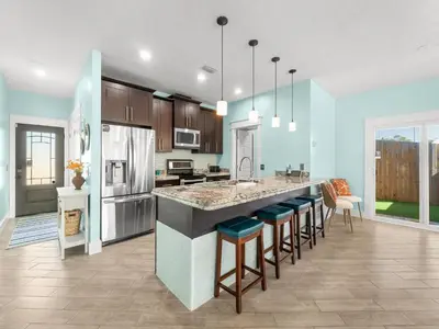 a kitchen with blue walls and a large island with bar stools at Orange Crush in Panama City Beach
