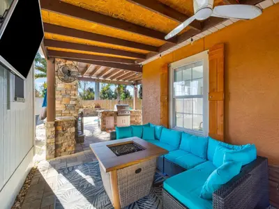 a patio with a blue couch and a table at Orange Crush in Panama City Beach