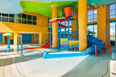 a playground with a slide in a building at Splash Beach Resort by Panhandle Getaways in Panama City Beach