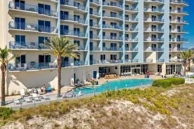 a view of a hotel with a swimming pool and palm trees at Sterling Breeze by Panhandle Getaways in Panama City Beach