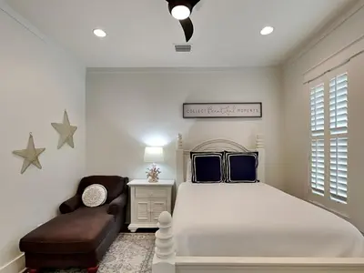 a bedroom with a large bed and a chair at Sunny Side Up in Inlet Beach