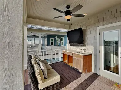 a living room with a couch and a tv on a porch at Sunny Side Up in Inlet Beach