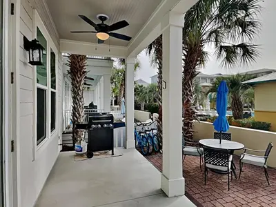 a porch with a ceiling fan and a table and chairs at Sunny Side Up in Inlet Beach