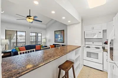 a kitchen and living room with a large counter top at Sunswept by Panhandle Getaways in Panama City Beach