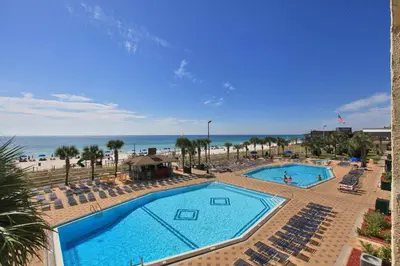 a view of a pool with chairs and the beach at The Summit by Panhandle Getaways in Panama City Beach