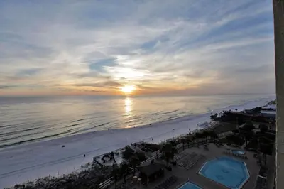 a view of the beach and the ocean at sunset at The Summit by Panhandle Getaways in Panama City Beach