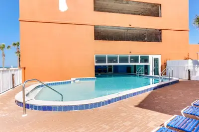 a swimming pool in front of a building at Tropic Winds Resort by Panhandle Getaways in Panama City Beach