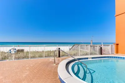 a swimming pool with the beach in the background at Tropic Winds Resort by Panhandle Getaways in Panama City Beach