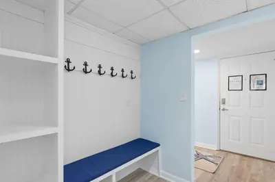 a room with white walls and a blue bench at Come Enjoy KC & The Sunshine State: 3-Bed, 3-Bath With Stunning Ocean Views in Panama City Beach