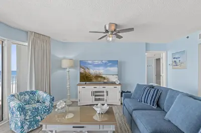 a living room with a blue couch and a table at Come Enjoy KC & The Sunshine State: 3-Bed, 3-Bath With Stunning Ocean Views in Panama City Beach