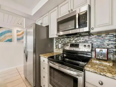 a kitchen with a stove and a microwave at Edgewater Tower III #1205 in Panama City Beach