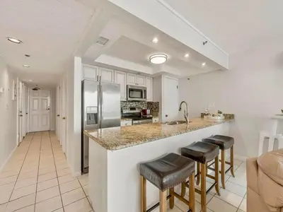 a kitchen with a large island with bar stools at Edgewater Tower III #1205 in Panama City Beach