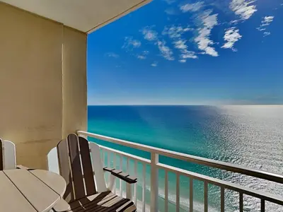 two chairs on a balcony looking out at the ocean at Emerald Beach #2531 in Panama City Beach
