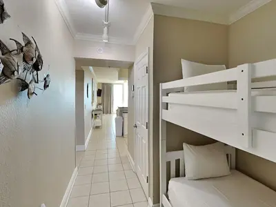a small room with a bunk bed and a hallway at Emerald Beach #2531 in Panama City Beach