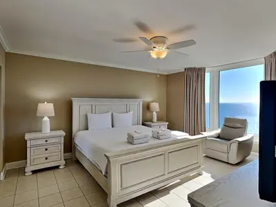 a bedroom with a bed and a window with the ocean at Emerald Beach #2531 in Panama City Beach