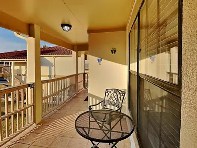 a balcony with a chair and a glass table at Horizon South #76G in Panama City Beach