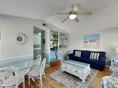a living room with a blue couch and a table at Horizon South #76G in Panama City Beach