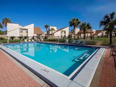 a swimming pool at a resort with palm trees at Horizon South #76G in Panama City Beach