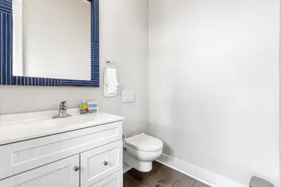 a bathroom with a toilet and a sink and a mirror at Modern Coastal Escape with Fire Pit & Pool Access in Inlet Beach