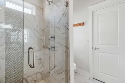a bathroom with a shower with a glass door at Modern Coastal Escape with Fire Pit & Pool Access in Inlet Beach