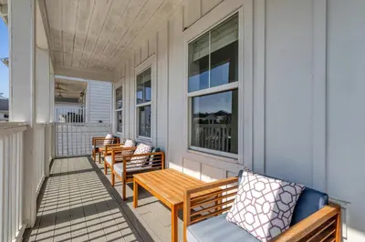 a porch with benches and a table and windows at Modern Coastal Escape with Fire Pit & Pool Access in Inlet Beach