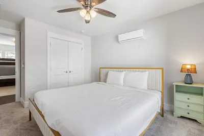 a white bedroom with a bed and a ceiling fan at Modern Coastal Escape with Fire Pit & Pool Access in Inlet Beach