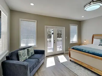 a bedroom with a bed and a couch and windows at Sunset On Seabreeze in Inlet Beach