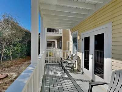a porch with two chairs on a house at Sunset On Seabreeze in Inlet Beach